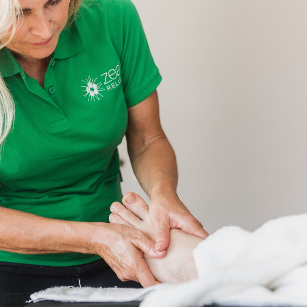 Zea Relief practitioner massaging a foot for plantar fasciitis relief